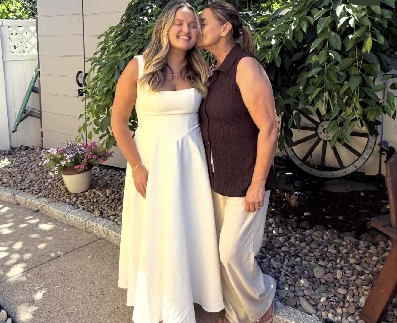 Layza's mother kissing her cheek in the backyard