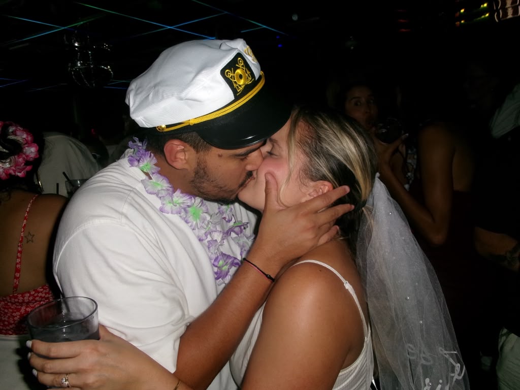 The couple kissing on the dance floor, veil catching the light