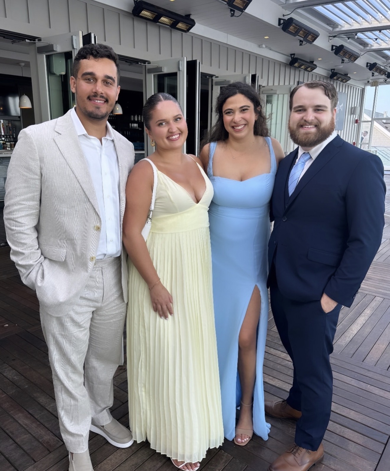 The couple with friends dressed up at a seaside wedding