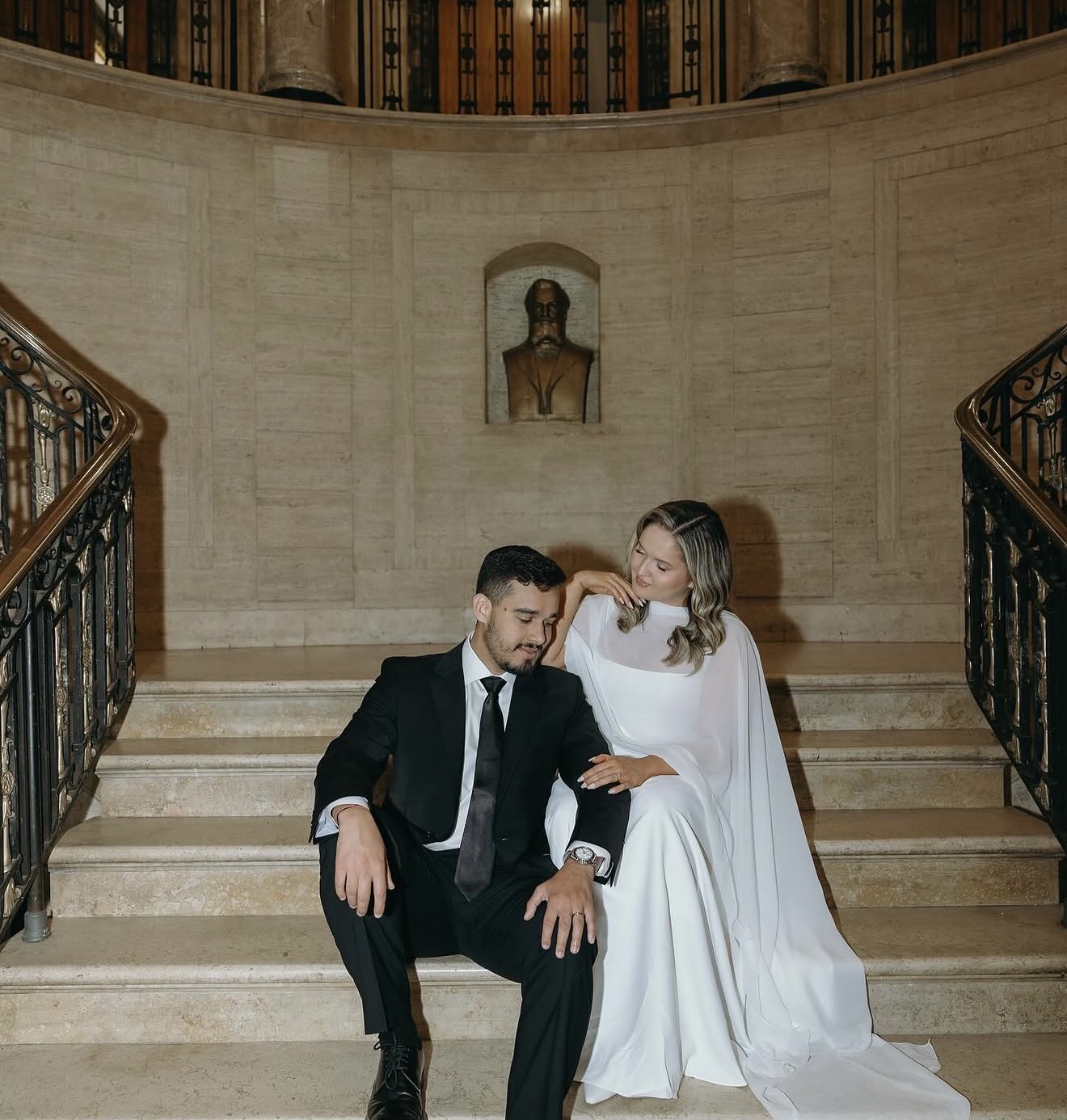 Matheus and Layza seated together on the grand staircase