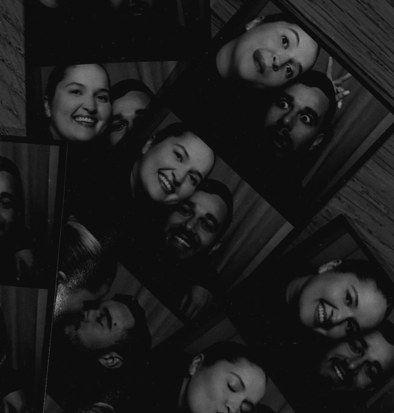 Black and white photobooth strips scattered on a wooden table