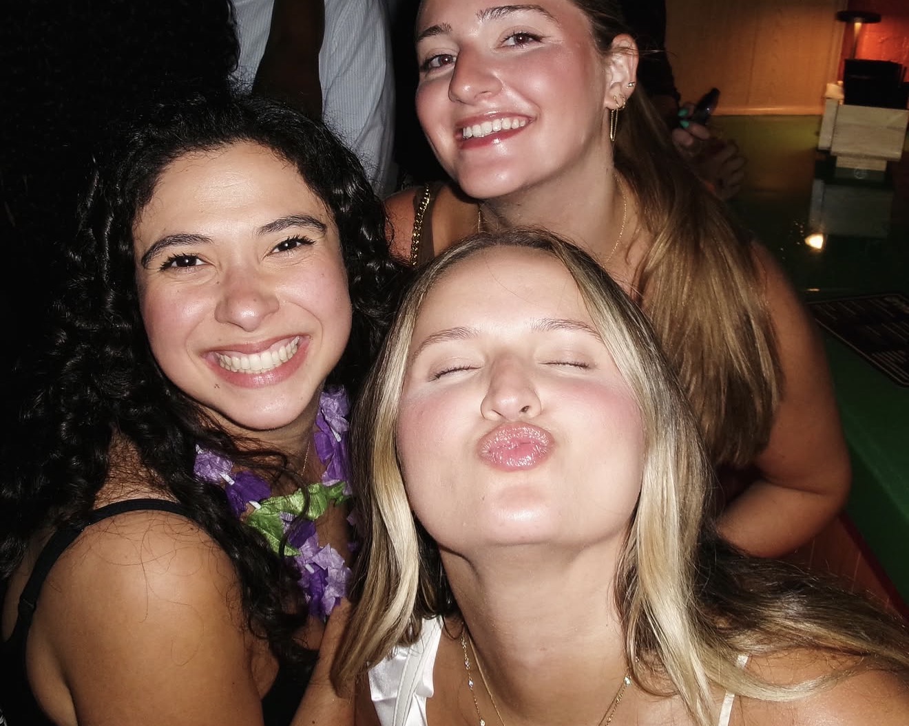 Three friends squeezing in for a flash selfie